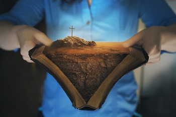 un homme ouvre sa Bible et y voit le mont Golgotha et La Croix de Jésus-Christ